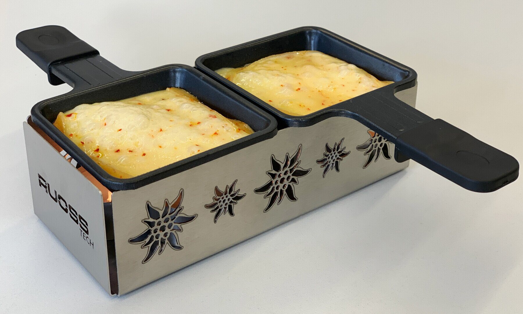 Raclette-Öfeli für zwei Personen mit Edelweiss-Lasermuster und geschmolzenem Käse