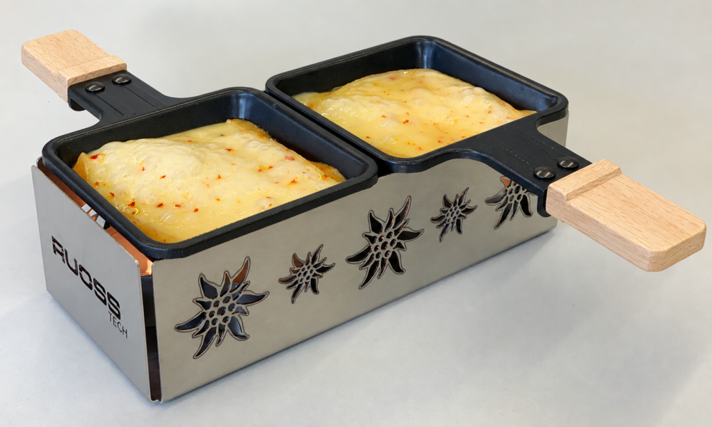 Raclette-Öfeli für zwei Personen mit Edelweiss-Lasermuster und geschmolzenem Käse